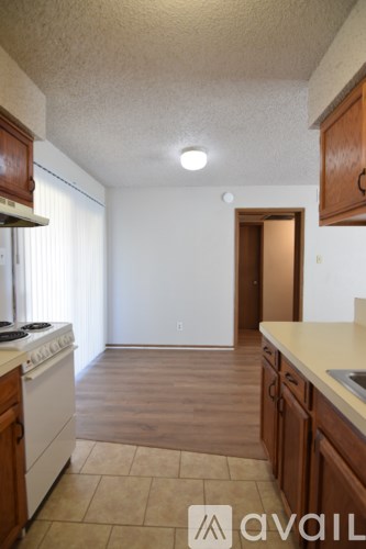 A kitchen with wooden cabinets and a white stove top oven.