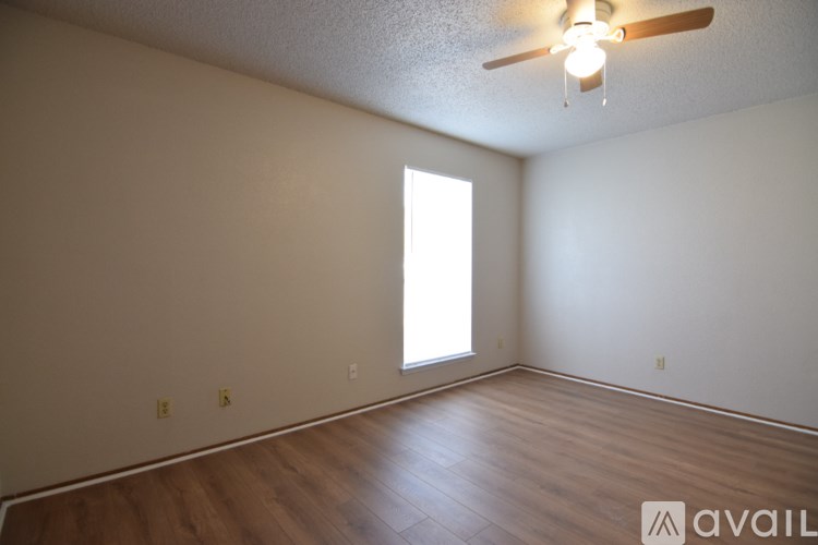 A room with a ceiling fan and wooden flooring.
