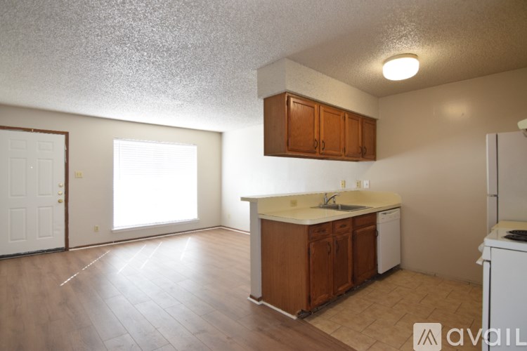 A kitchen with wooden cabinets and a white dishwasher.