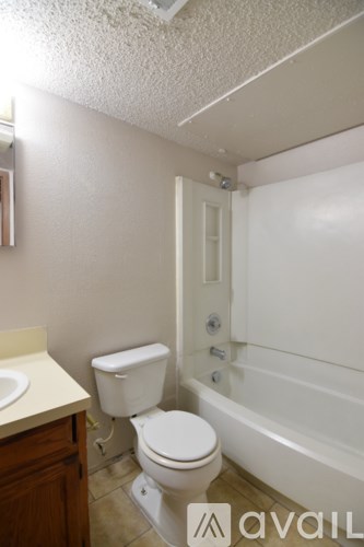 A white toilet sits next to a bathtub in a bathroom.