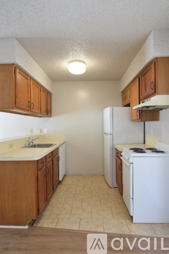 A kitchen with wooden cabinets and a white fridge.