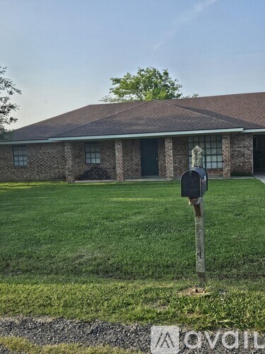 A brick house with a mailbox in front.