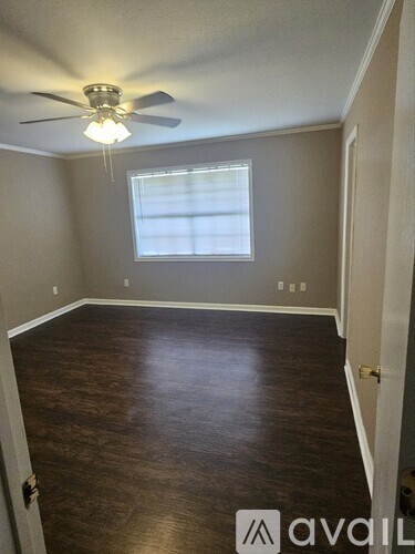 A room with a ceiling fan and a window.