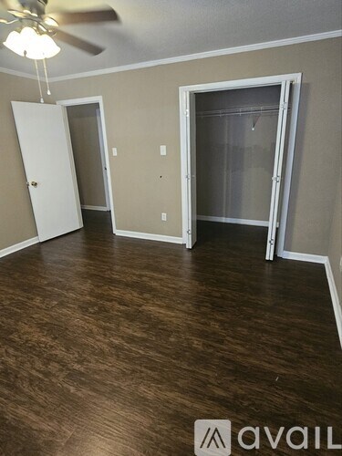 A room with a ceiling fan and two doors, one of which is open.