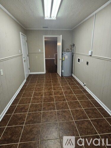 A room with brown tiles on the floor and a white door.