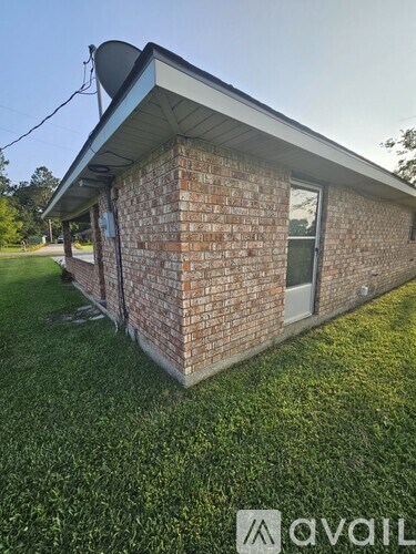 A small brick house with a satellite dish on the roof.