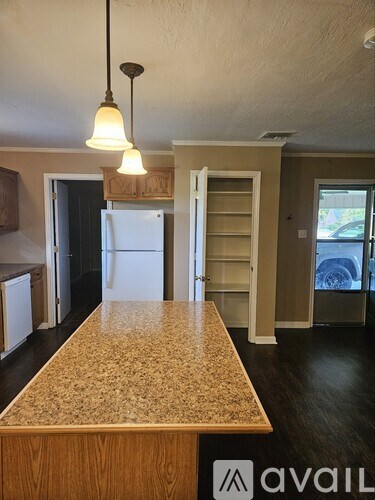 A kitchen with a granite counter top and a refrigerator.