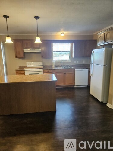 A kitchen with a white refrigerator and wooden cabinets.