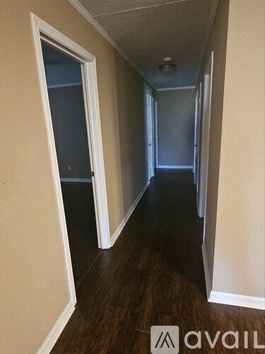A hallway with a door on the left and a door on the right.