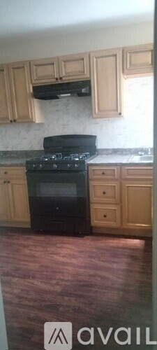 A kitchen with wooden cabinets and a black stove top oven.