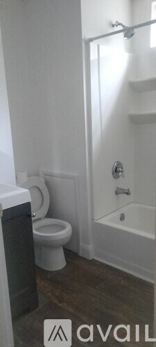 A bathroom with a toilet, a bathtub, and a shower curtain.
