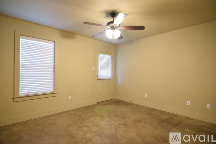 A room with a ceiling fan and a door.