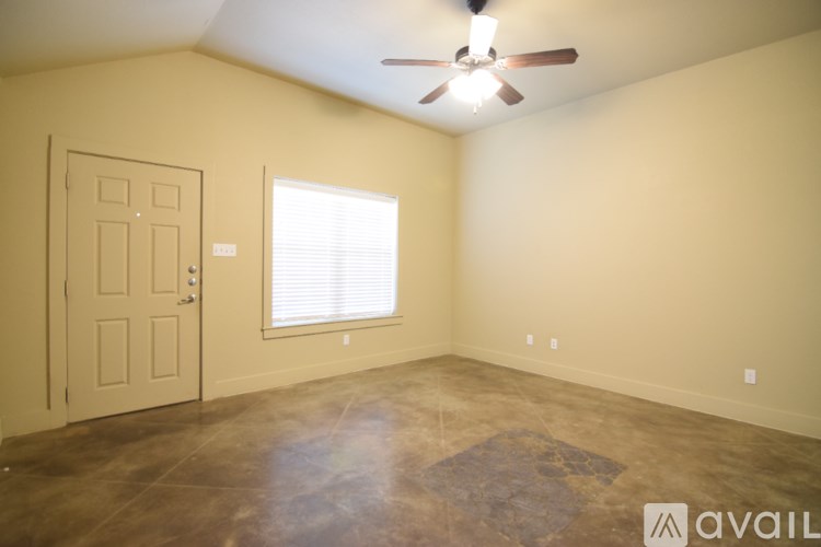 A room with a ceiling fan and a rug on the floor.