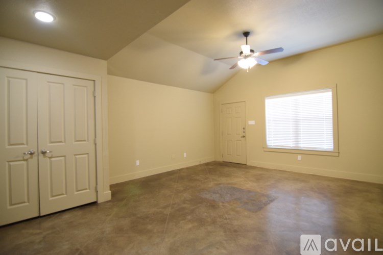 A room with a ceiling fan and a window with blinds.