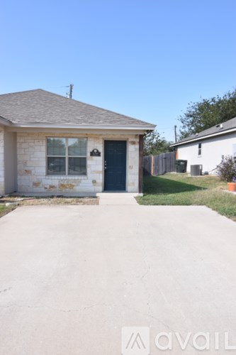 A small house with a grey roof and a blue door.