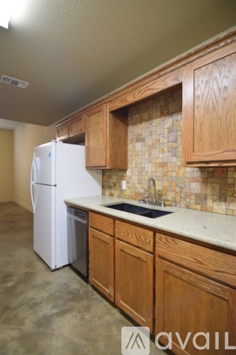 A kitchen with wooden cabinets and a white fridge.