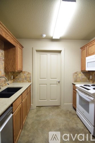 A kitchen with wooden cabinets and a white door.
