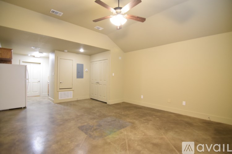 A spacious room with a ceiling fan and a rug on the floor.