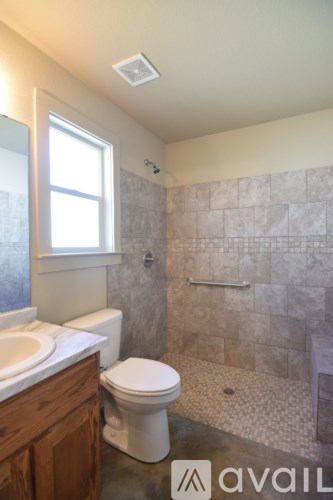 A bathroom with a toilet, sink, and shower.