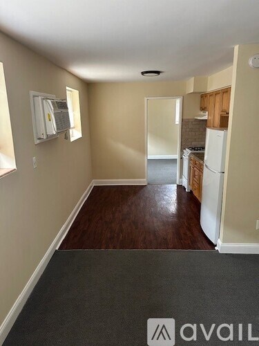 A room with a carpeted floor and a wall-mounted air conditioner unit.