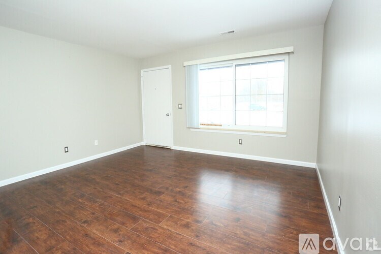 A room with wooden flooring and a window.