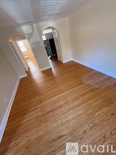 A hallway with wooden floors and white walls.