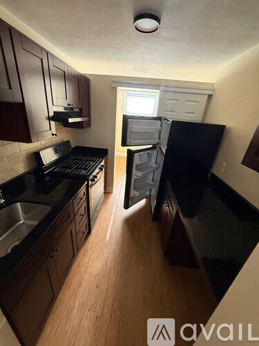 A kitchen with black appliances and wooden cabinets.