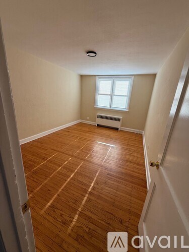 A room with wooden flooring and a window.