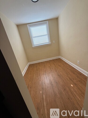 A room with wooden flooring and a window.