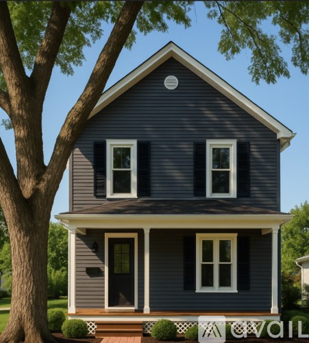 A small house with a dark grey exterior and white trim.