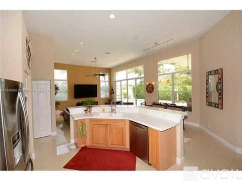 A kitchen with a refrigerator on the left and a counter with a sink.