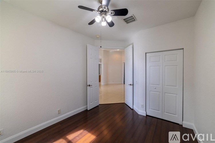 A room with a ceiling fan and two doors.