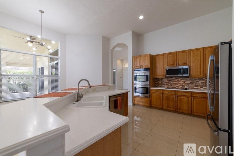 A kitchen with wooden cabinets and a white countertop.