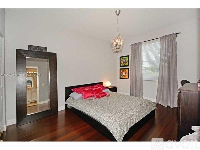 A bedroom with a large bed and a chandelier.