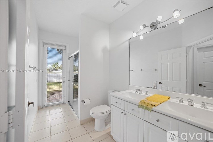 A bathroom with a white toilet, sink, and mirror.