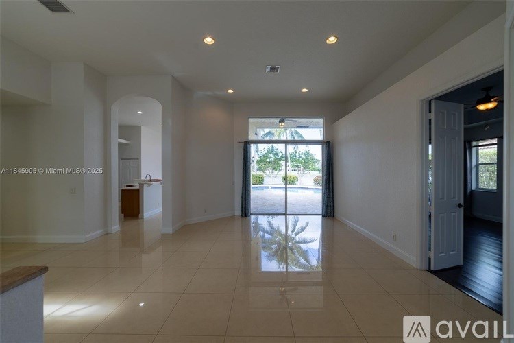 A spacious living room with a view of the backyard through the open door.
