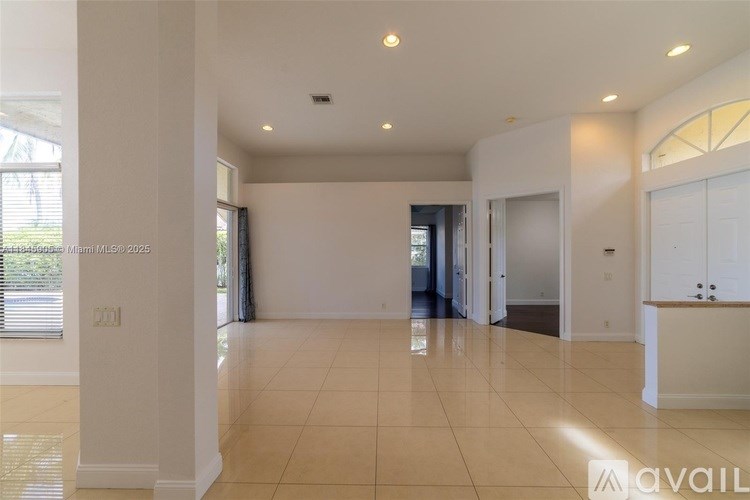 A spacious, empty room with a tiled floor and white walls.
