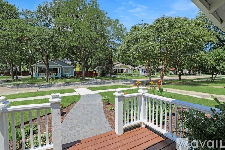 A white railing leads to a house with a blue roof.