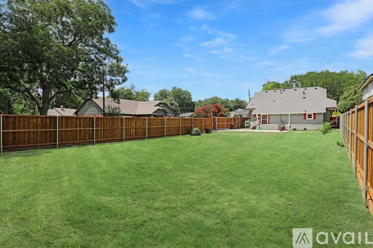 A backyard with a fence and a house in the background.