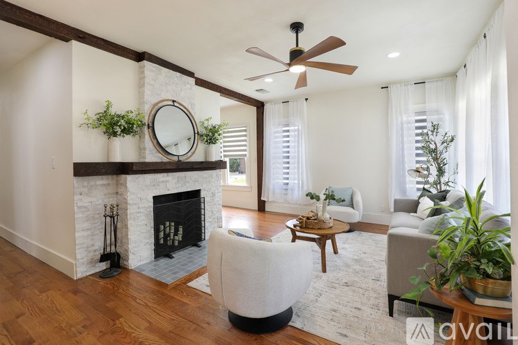 A living room with a fireplace and a ceiling fan.