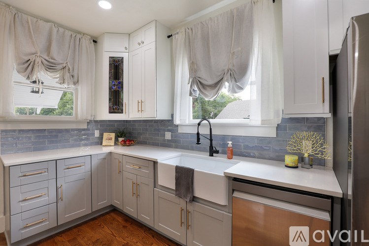 A kitchen with white cabinets and a wooden floor.