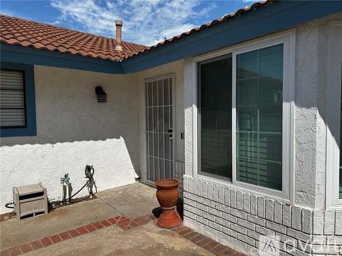 A house with a red tile roof and a white wall with a window and a door.
