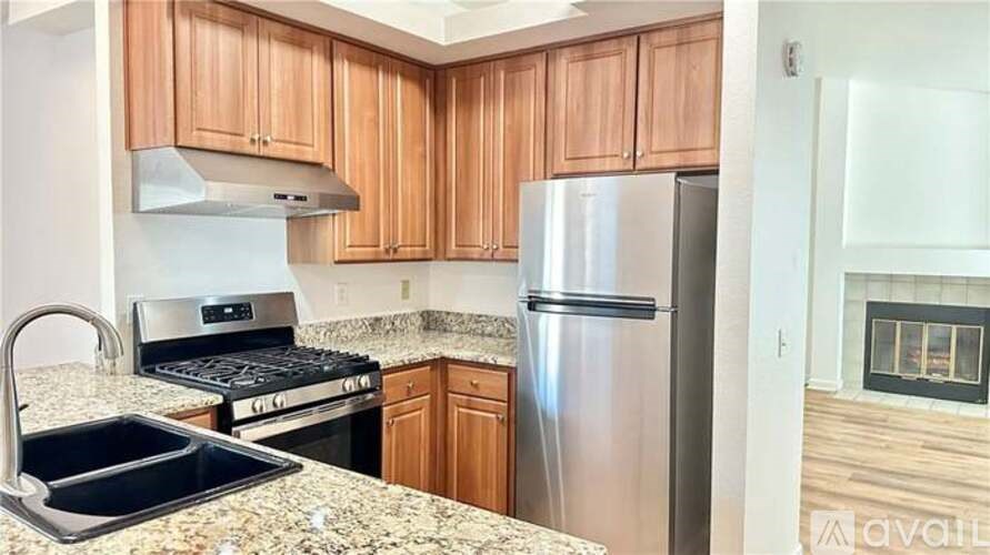 A kitchen with wooden cabinets and a granite countertop.