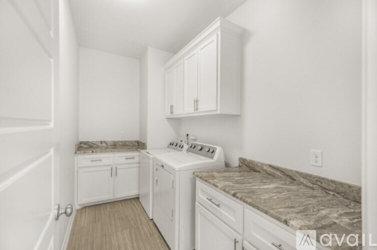 A kitchen with white cabinets and a marble countertop.