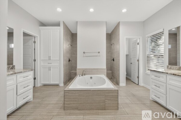 A spacious bathroom with a large tub in the center.