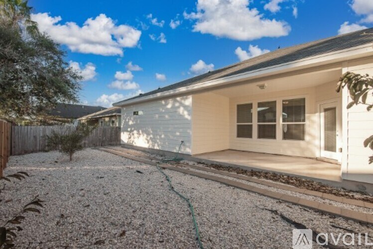 A house with a gravel driveway and a hose is for sale.