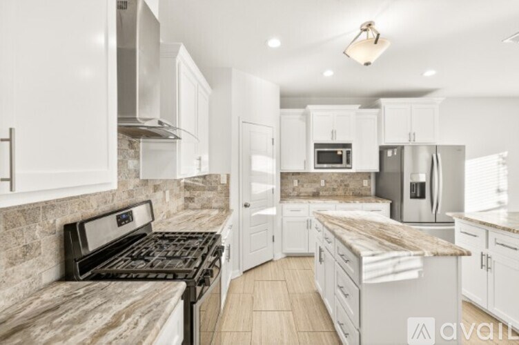 A kitchen with white cabinets and a granite countertop.