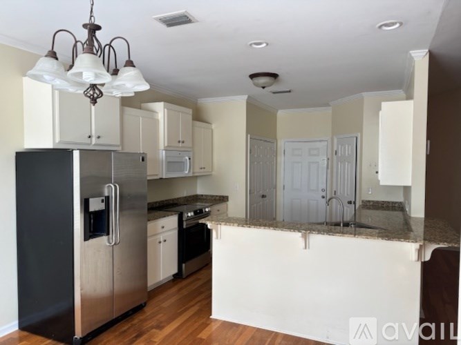A kitchen with a refrigerator, microwave, and oven.