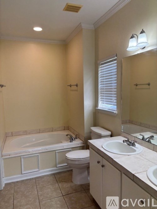 A bathroom with a tub, toilet, and sink.