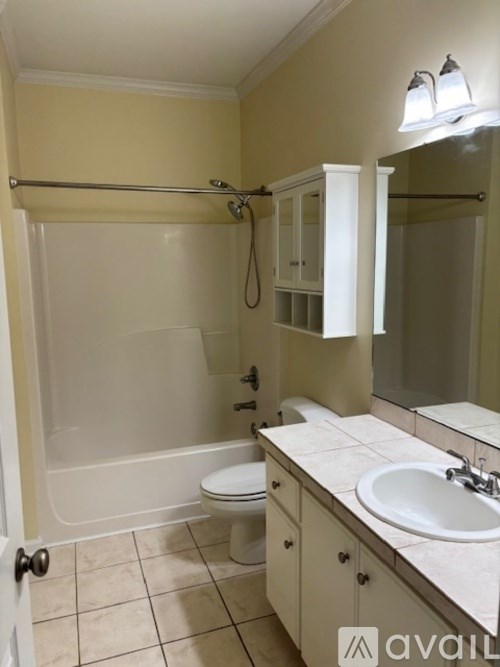 A bathroom with a toilet, sink, and shower.